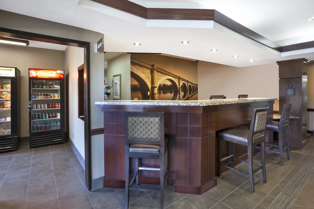 A friendly, inviting communal area featuring a bar counter with stools, vending machines for snacks, and artwork on the wall. The space is well-lit and encourages both solo relaxation and social interaction, ideal for guests grabbing a morning coffee or meeting fellow travelers before heading out to explore local attractions.
